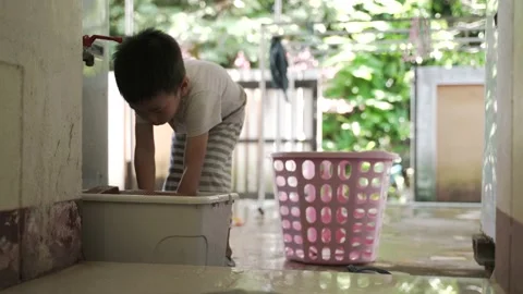 Asian boyhelp doing chores by washing shoes Video stock 144663945