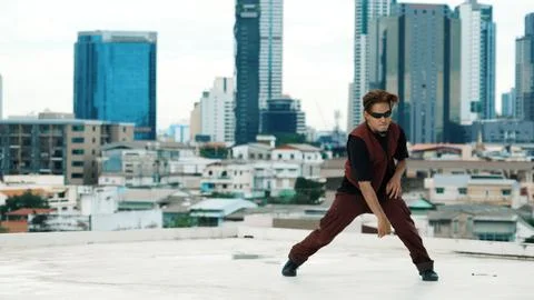Asian break dancer practice B boy dance with friends at roof top. Endeavor. Stock Photos