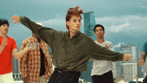 Asian break dancer practice B boy dance with friends at roof top. Endeavor. Stock Photos