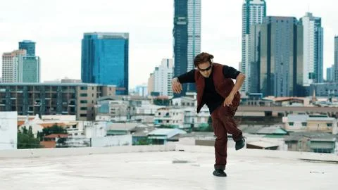 Asian break dancer practice B boy dance with friends at roof top. Endeavor. Stock Photos
