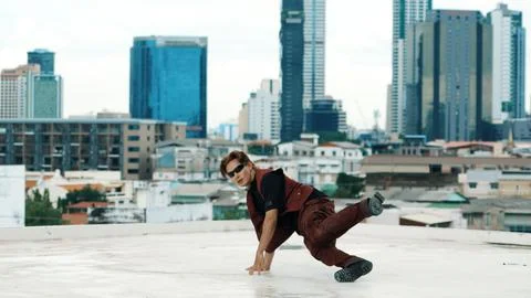 Asian break dancer practice B boy dance with friends at roof top. Endeavor. Stock Photos