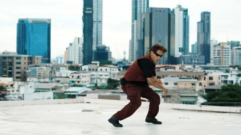 Asian break dancer practice B boy dance with friends at roof top. Endeavor. Stock Photos