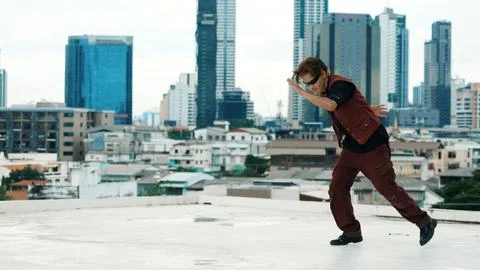 Asian break dancer practice B boy dance with friends at roof top. Endeavor. Stock Photos
