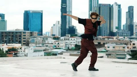 Asian break dancer practice B boy dance with friends at roof top. Endeavor. Stock Photos