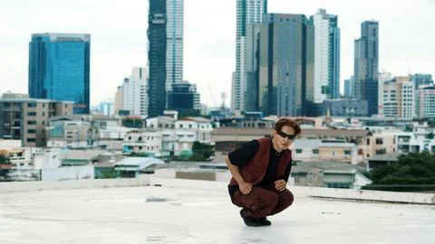 Asian break dancer practice B boy dance with friends at roof top. Endeavor. Stock Photos