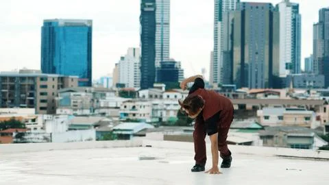 Asian break dancer practice B boy dance with friends at roof top. Endeavor. Stock Photos
