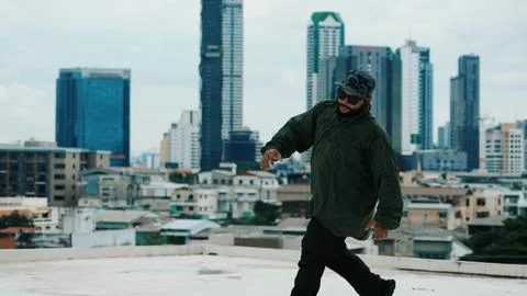 Asian break dancer practice B boy dance with friends at roof top. Endeavor. Stock Photos