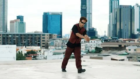 Asian break dancer practice B boy dance with friends at roof top. Endeavor. Stock Photos