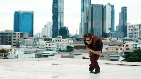 Asian break dancer practice B boy dance with friends at roof top. Endeavor. Stock Photos