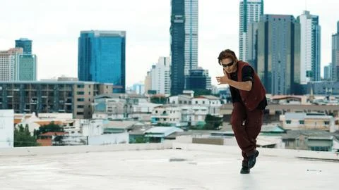Asian break dancer practice B boy dance with friends at roof top. Endeavor. Stock Photos