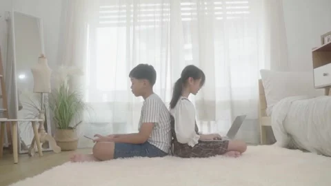 Asian brother and sister using laptop and  tablet to learn at home. 動画素材 240801088