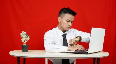 Asian business man see clock on hand isolated red background Stock Photos