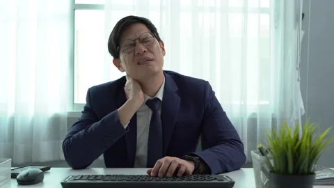 Asian business man in suit using computer on desk in office suffering from .. Stock Footage 252825791