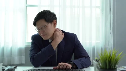 Asian business man in suit using computer on desk in office suffering from .. Stock Footage 252825958