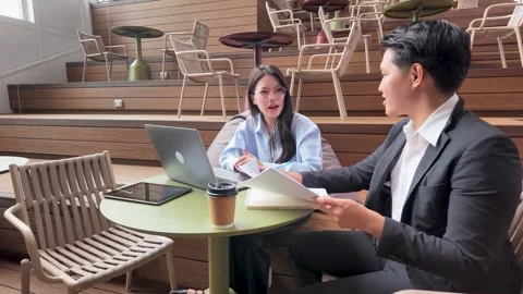 Asian Business Professionals Discussing Documents in Modern Bangkok Stock Footage 344710975