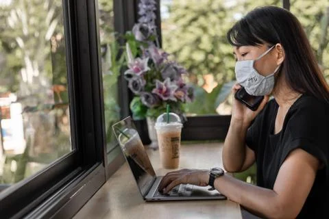 Asian Business Woman Working with Laptop and Talking Phone in Coffee Shop Stock Photos