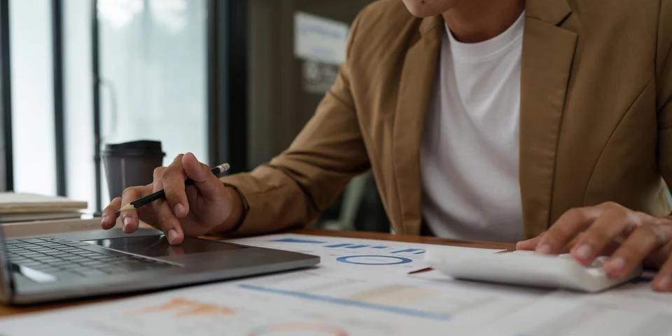 Asian businessman checking information while working with satisfaction on his Stock Photos