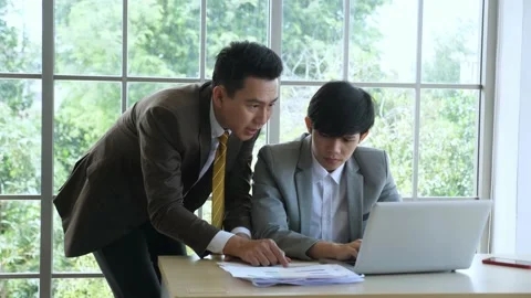 Asian businessman discuss work, helping junior employee to solve problem Stock Footage 139698317
