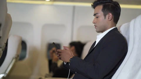 Asian businessman passengers using smartphone sitting in airplane Stock Footage 167056072