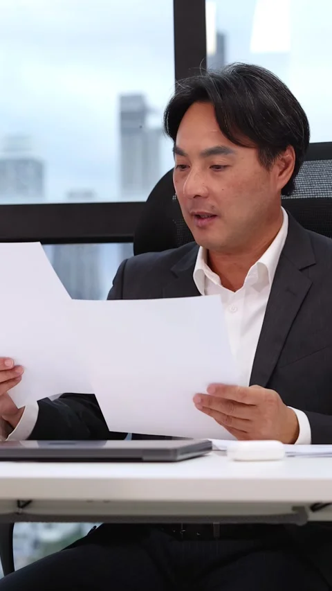 Asian Businessman Reading Documents During Professional Job Interview in Office Stock Footage 326619370
