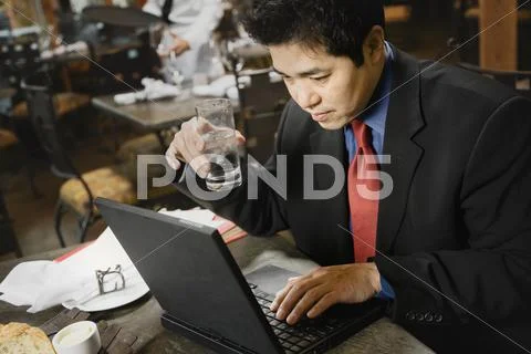 Asian businessman typing on laptop Stock Photos