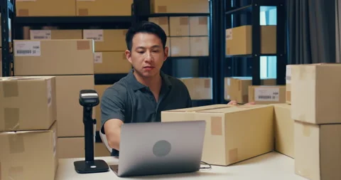 Asian businessman use barcode machine scan and type detail in laptop. Stock Footage 202126528