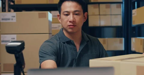 Asian businessman use barcode machine scan customer data in paper box. Stock Footage 203411525