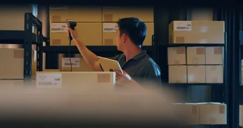 Asian businessman use barcode scanner scan paper box in shelf. Stock Footage 202133301