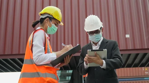 Asian businessman using digital tablet and harbor worker woman  wareing face Stock Footage 154685869