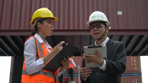 Asian businessman using digital tablet and harbor worker woman   holding clip Stock Footage 154686087