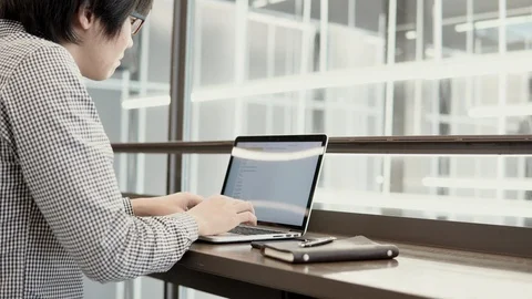 Asian businessman using laptop computer and smartphone on desk Stock-Footage 91076657