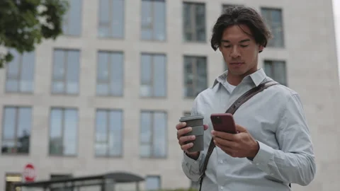 Asian businessman using mobile while walking on street Video stock 165839399