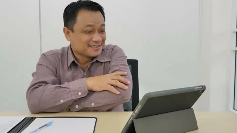 Asian businessman is using a tablet computer to the video conference. Video stock 141126496
