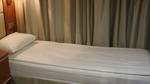 An Asian cabin steward makes a bed onboard a cruise ship Stock Footage 104994826