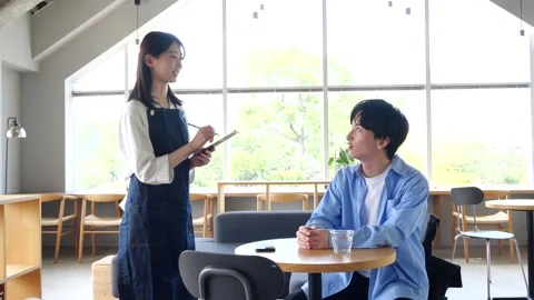 Asian Cafe Staff Taking Order from Male Customer at Table Stock Footage 344092311