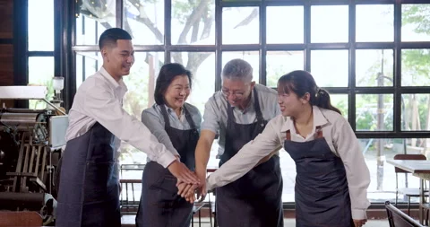 Asian cafe team celebrates unity slowmotion scene, elderly owners and young Stock Footage 333548082