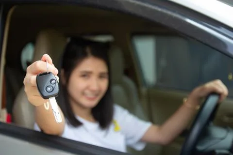 Asian car driver woman smiling showing new car key..Happy young girl owner ta Stock Photos