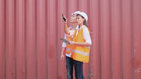 Asian cargo container worker man and woman work and discuss together Stock Footage 146457176