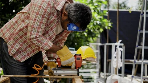 Asian carpenter worker wearing protective gloves is using power drill assembling Stock Footage 228943871