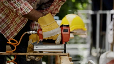 Asian carpenter worker wearing protective gloves is using power drill assembling Stock Footage 228943874