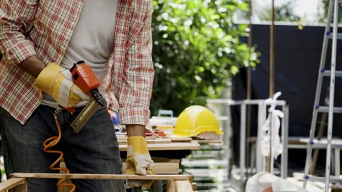 Asian carpenter worker wearing protective gloves is using power drill assembling Stock Footage 229068589