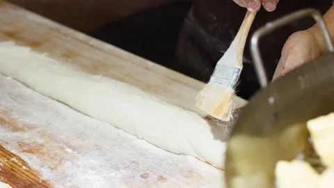 Asian Chef Brushing and Cutting Dough on Wooden Bench Video stock 340966681