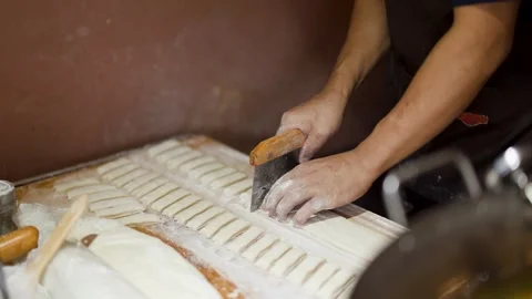 Asian Chef Cutting Fresh Dough Strips for Street Food Preparation Stock Footage 339514877
