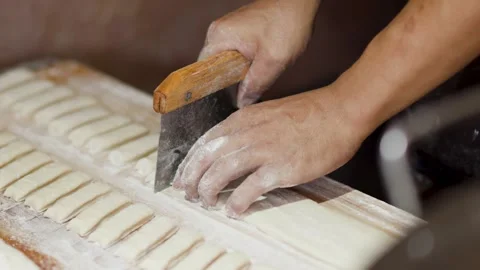 Asian Chef Cutting Fresh Dough Strips for Street Food Bread Making Stock Footage 340194123