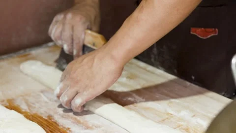 Asian Chef Hands Cutting and Rolling Dough on Wooden Board Stock Footage 339545349