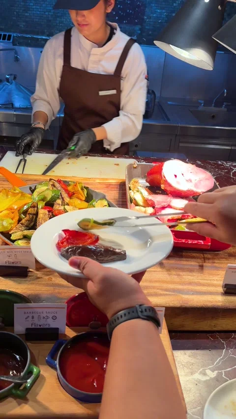 Asian Chef Serving Roasted Ham and Grilled Vegetables at Hotel Buffet Stock Footage 335797129
