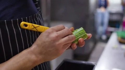 Asian Chef Slicing Fresh Cucumber with Precision in Professional Kitchen Stock Footage 337227009