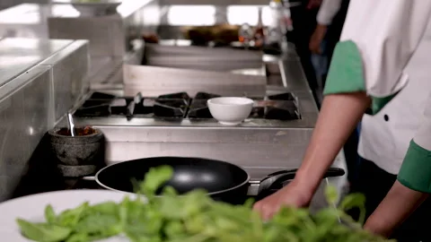 Asian chef worker stir vegetable on a hot pan, Elderly man with a uniform c.. Stock Footage 245138820