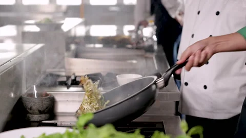 Asian chef worker stir vegetable on a hot pan, Elderly man with a uniform c.. Stock Footage 245140305