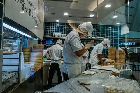 Asian chefs preparing dim sum in busy kitchen Stock Photos